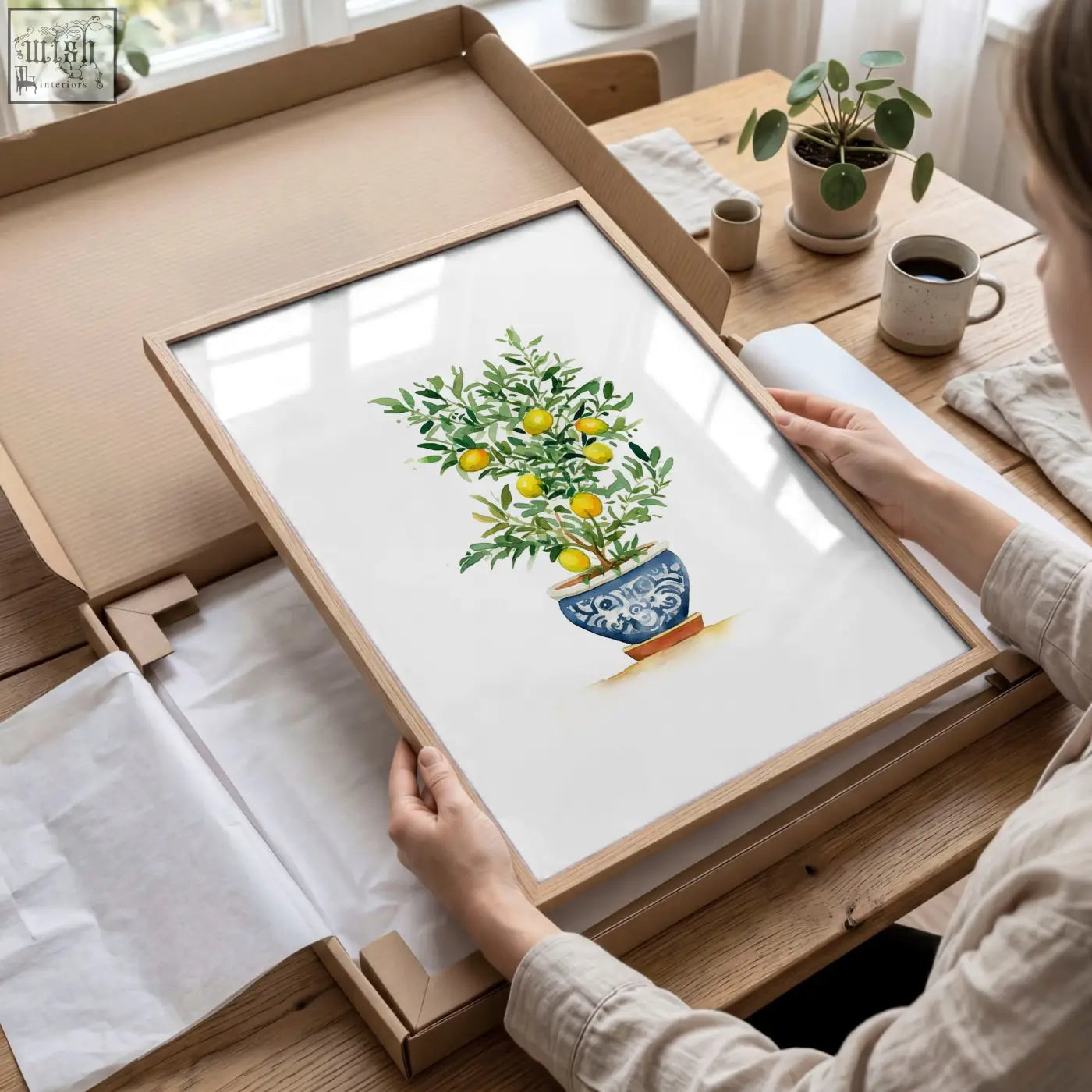 Framed bedroom picture of a lemon tree in a blue and white ceramic pot with a light wood frame french country style