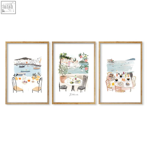 Set of three light wood framed bedroom prints featuring mediterranean coastal dining scene inspired by dolce vita