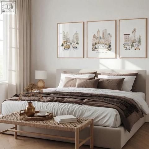 Beige upholstered bed with layered white and brown bedding and bedroom wall prints winter in new york set of 3