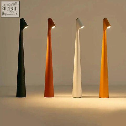 Four slender tapered floor lamps in matte black orange white and mustard yellow perfect for minimal space living rooms
