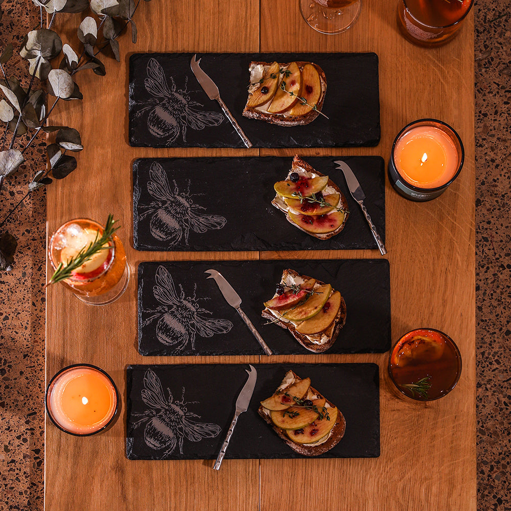 Set of 4 black mini slate cheese boards engraved with white bee designs and matching silver knives for serving