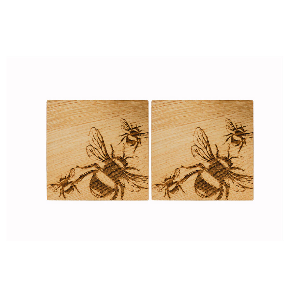 Two light british oak coasters with dark brown engraved bee designs perfect for stylish tabletops