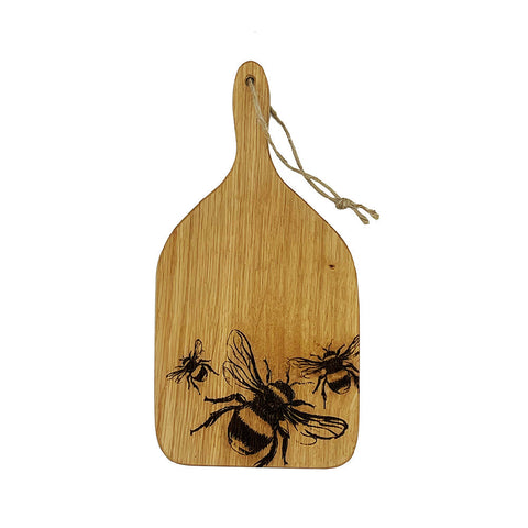 A light brown british oak hanging paddle with a handle and three dark brown engraved bees design