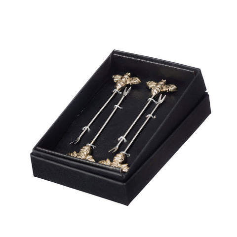 A set of 4 bee olive picks with ornate gold-toned bee tops and silver metal handles for stylish cocktail garnishes