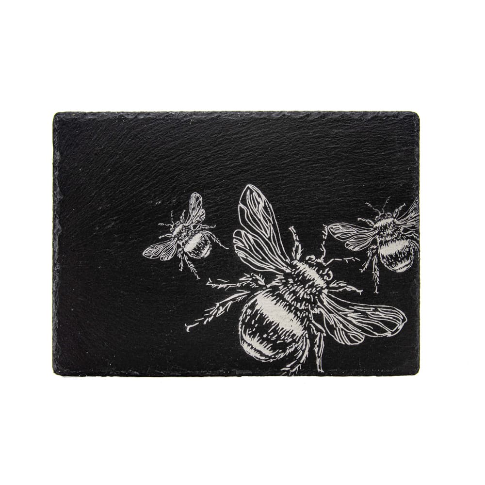 Black slate serving board with white etched bee design included in bee slate placemat and coaster gift set