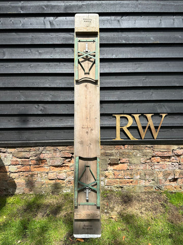 A vintage wooden beer festival fold up bench with green metal brackets and a white marker for garden seating