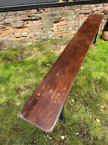 A long dark brown wooden rustic beer festival fold up bench perfect for picnic garden or hallway seating