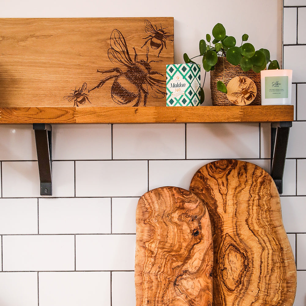 Natural wood cutting boards with swirling grain patterns complementing bees fresh fennel carrot candle design