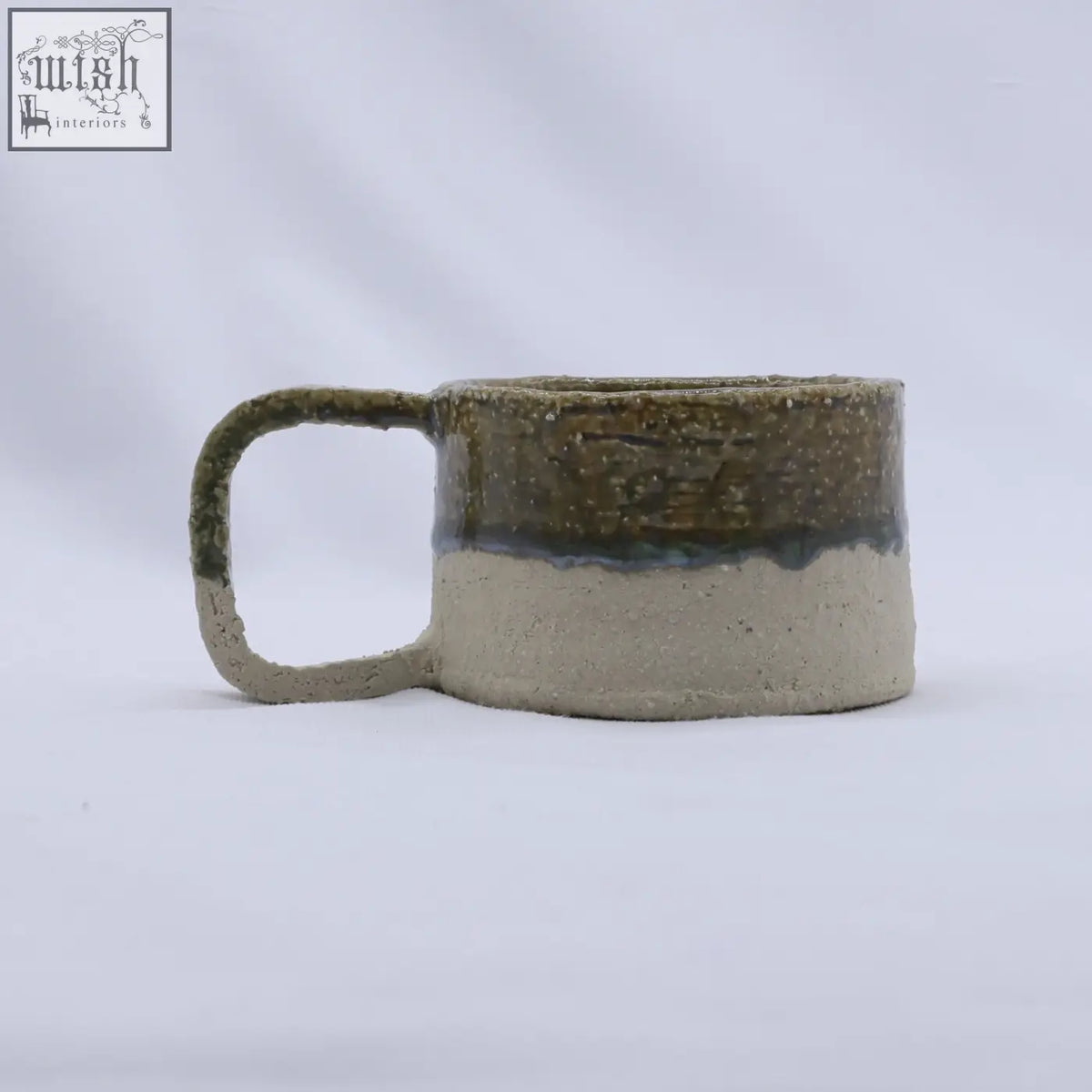 Beige grande handmade milled stoneware mug with speckled olive green glaze and matte beige base with loop handle