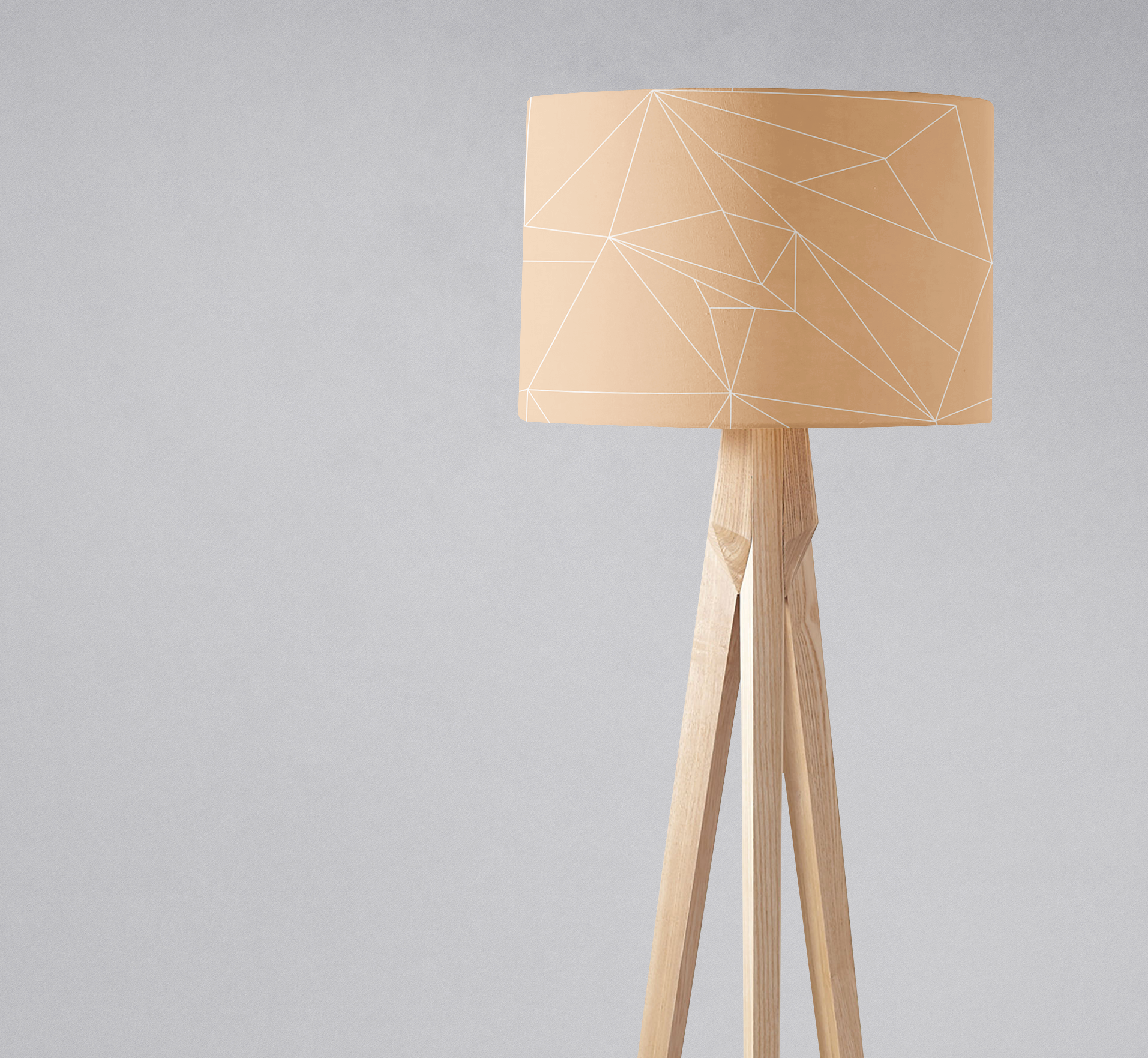 Beige minimalist lampshade with geometric pattern mounted on light wood tripod table lamp base