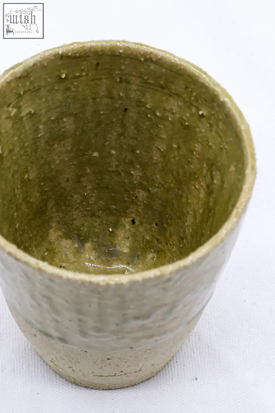 Handcrafted beige quadra milled stoneware tall ceramic cup with textured olive green matte glaze and subtle speckles