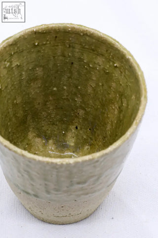 Handcrafted beige quadra milled stoneware tall ceramic cup with textured olive green matte glaze and subtle speckles