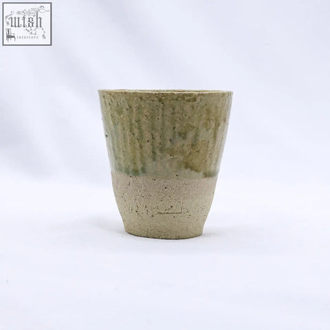 Beige quadra milled stoneware tall ceramic cup with earthy green glaze and unglazed clay base handcrafted rustic design