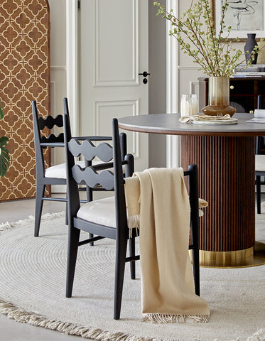 Black wooden chair with white cushion and beige throw blanket next to bek round dining table brown for round dining