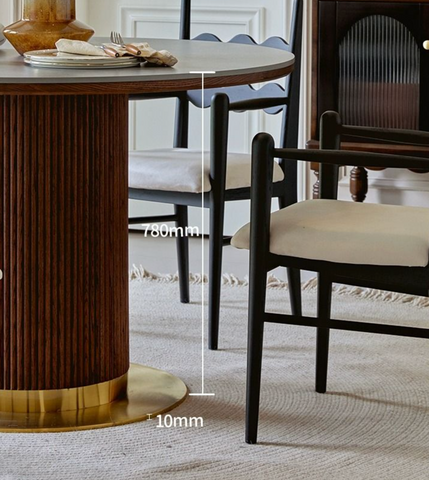 Bek round dining table with dark wood top featuring vertical grooves and a gold-colored circular base