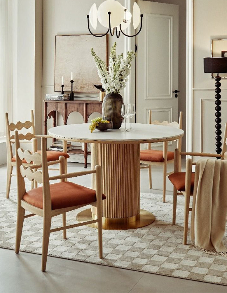Bek round dining table with white marble top and honey-toned ribbed wooden base with polished brass foot