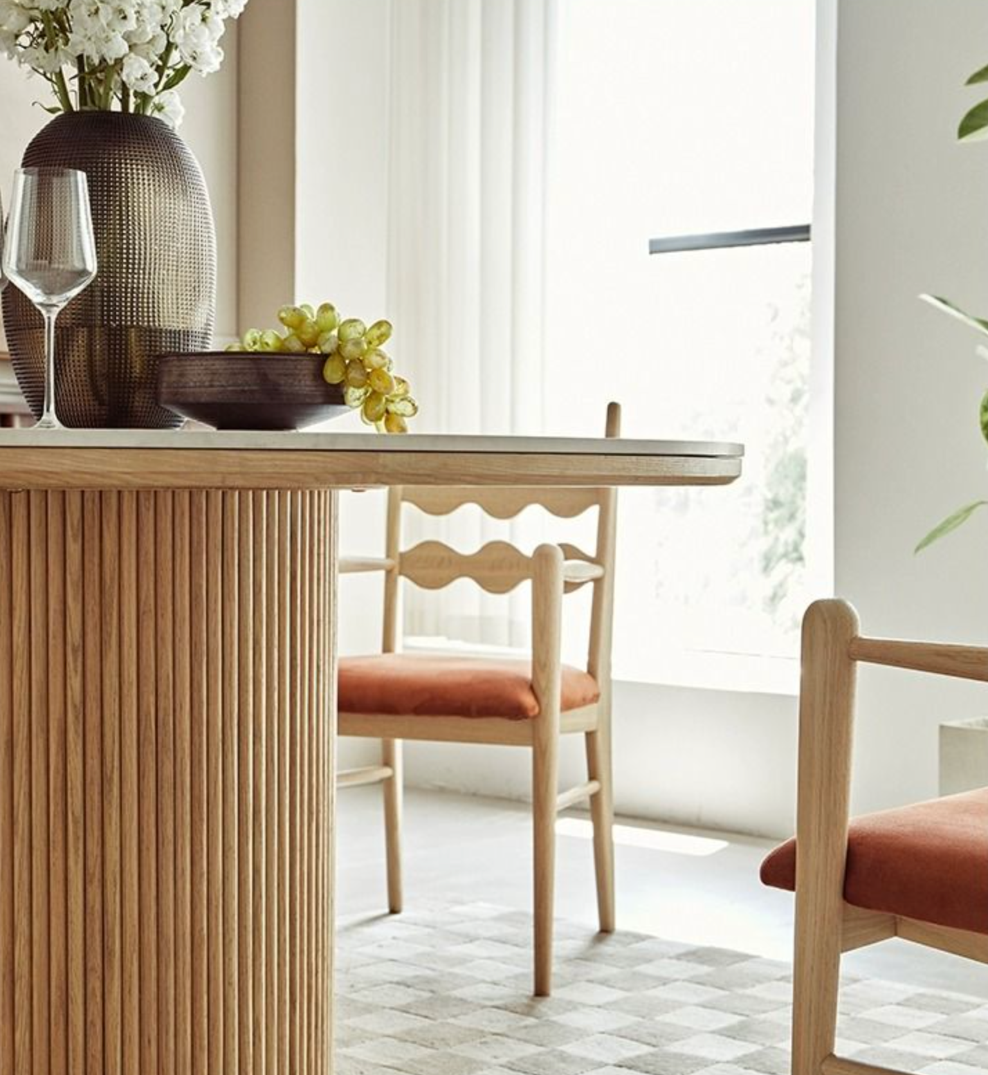 Bek round dining table features a modern round dining design with a light wood ribbed base and concrete top