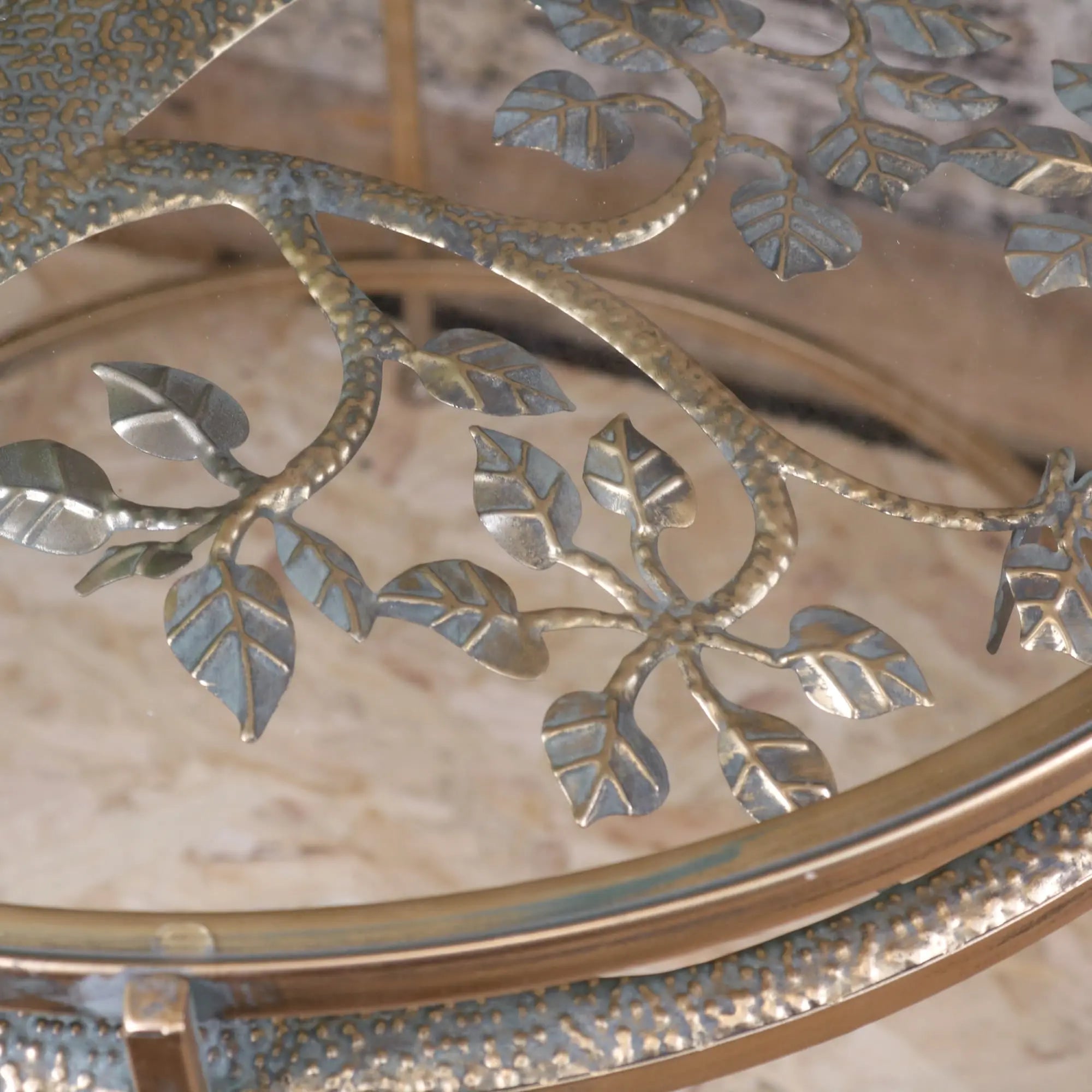 A belagavi gold round decorative glass-top coffee table with ornate metallic leaf and branch design in brushed gold finish