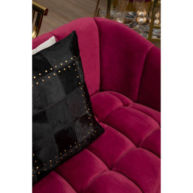 A bella 3 seat wine velvet sofa in deep magenta with quilted texture and a black patchwork pillow with gold studs