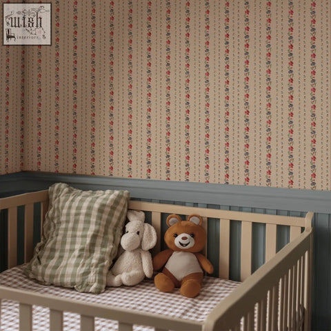 A soft beige wooden crib with vertical slats and checkered mattress pad in belle buds blush wallpaper style