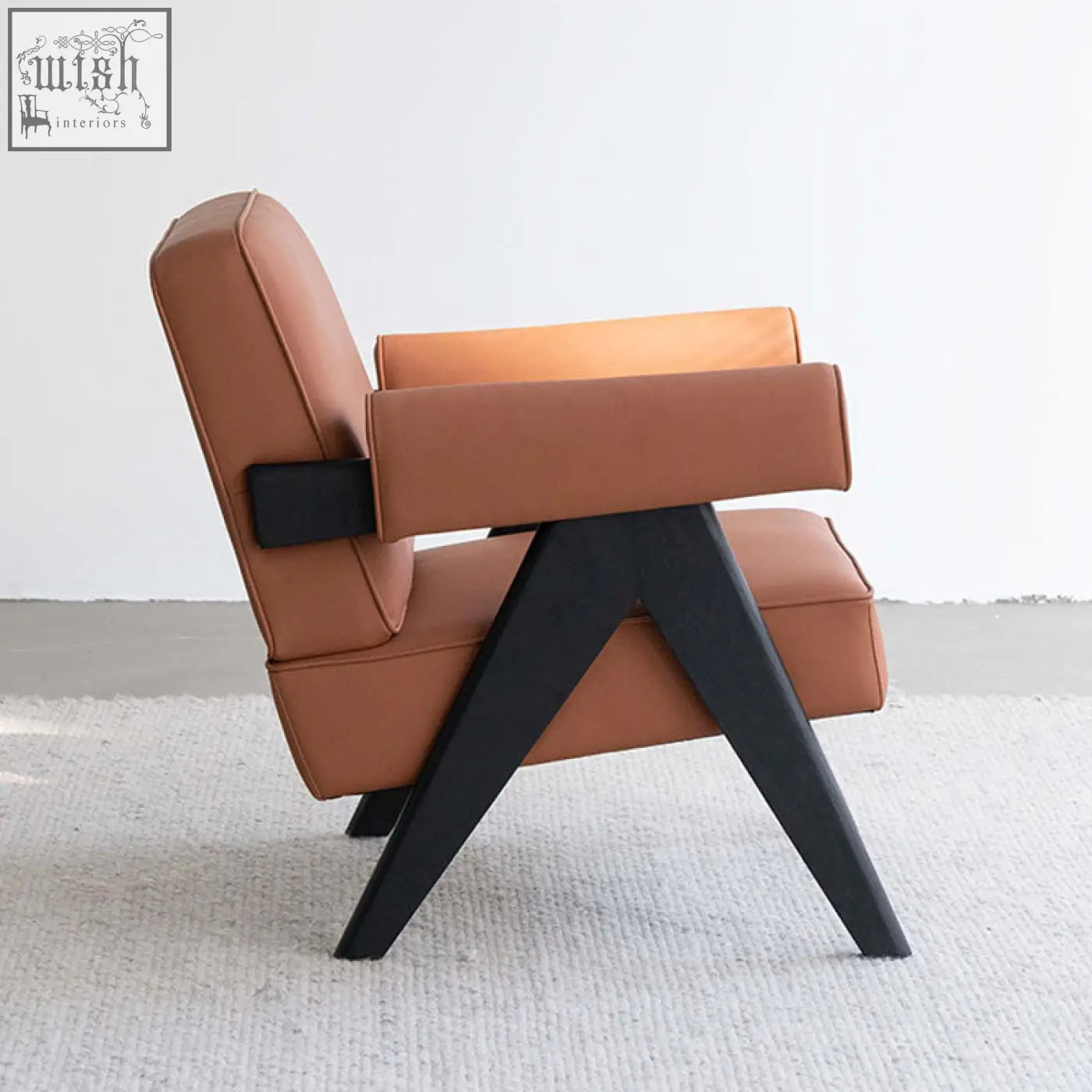 Bertran armchair in brown microfiber leather with tan leather upholstery and black wooden legs in an angular design