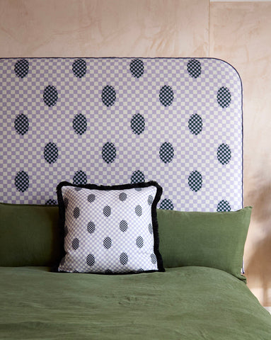 Bespoke headboard 120cm tall with light gray and black checkered fabric, bold polka dots, and dark piped trim
