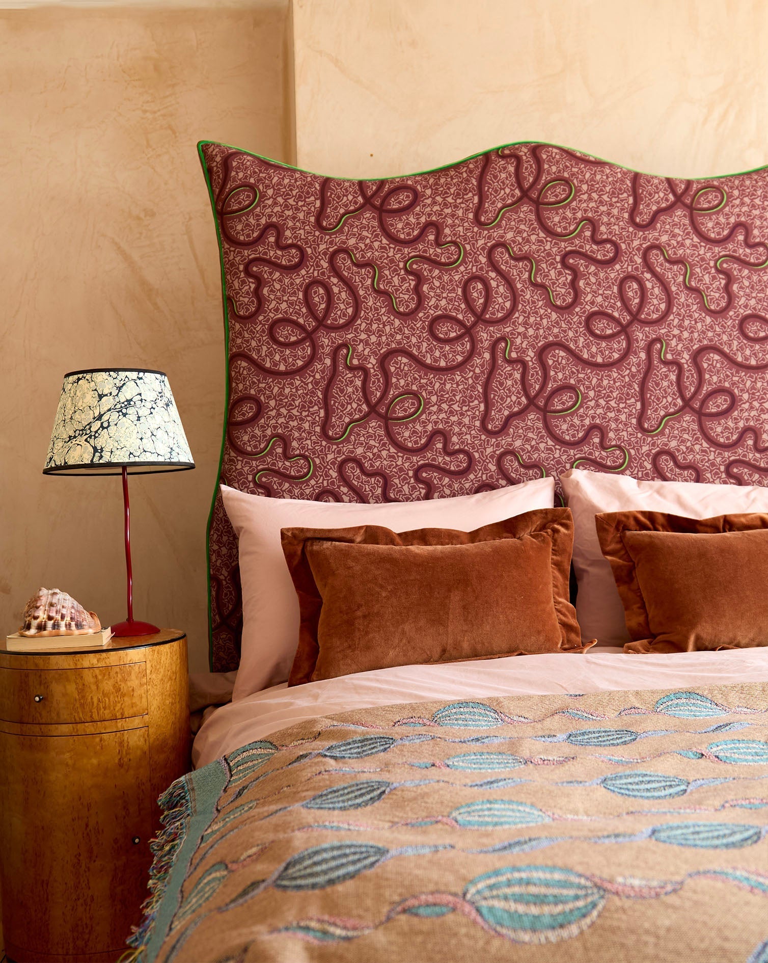 Bespoke headboard from micaela sharp collaboration with burgundy piped headboard 120cm tall and intricate green patterns