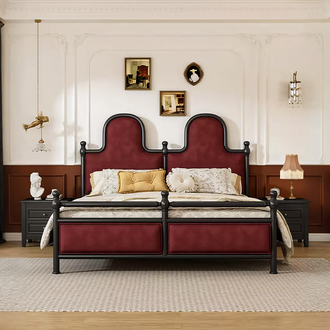 A luxurious betty king size bed with burgundy velvet upholstery and an ornate black metal headboard and footboard