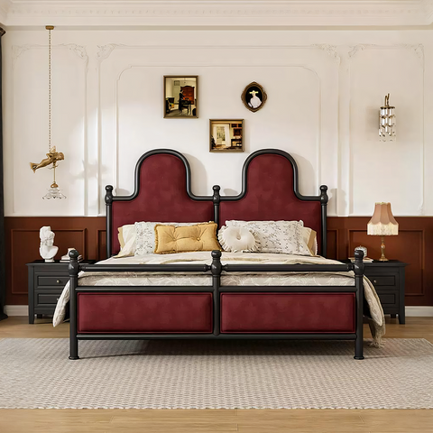 A luxurious betty king size bed with burgundy velvet upholstery and an ornate black metal headboard and footboard