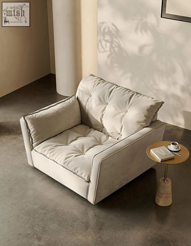 Cream-colored tufted velvet bhatia swivel snuggle chair with dark piping and swivel feature for cozy seating