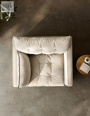 Cream-colored tufted swivel snuggle chair with clean lines soft plush cushions in beige for cozy seating
