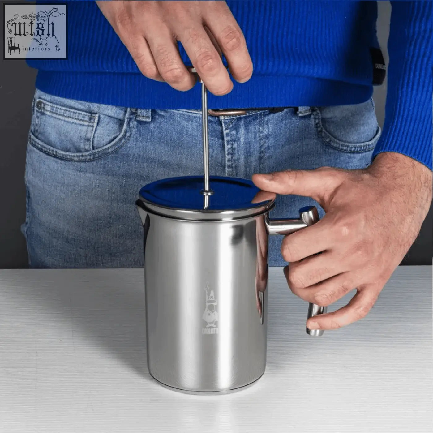 Silver stainless steel bialetti manual milk frother with a blue lid and engraved logo perfect for frothing milk