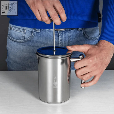 Silver stainless steel bialetti manual milk frother with a blue lid and engraved logo perfect for frothing milk