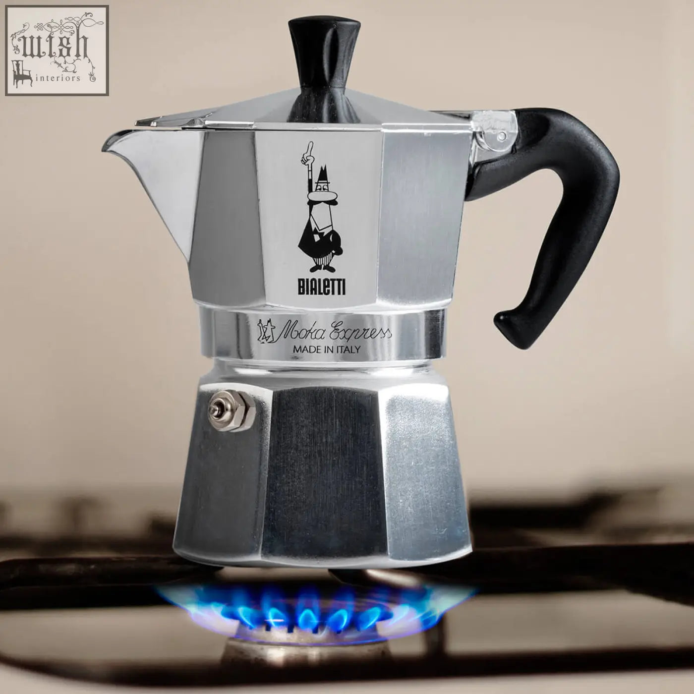 Silver bialetti moka express espresso maker with black plastic handle lid and iconic cartoon logo for bialetti moka express
