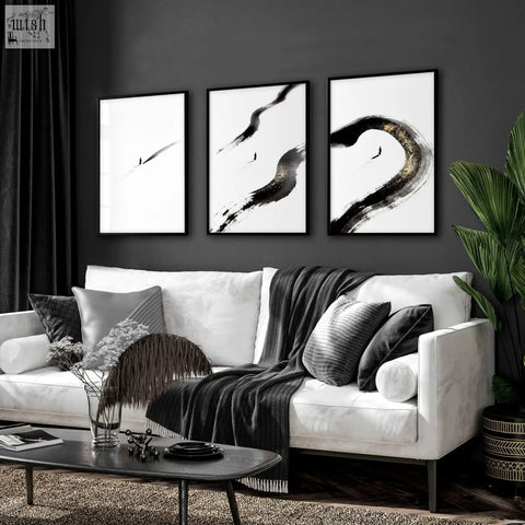 Black and white abstract living room wall art triptych with bold brushstrokes and subtle gold shimmer on right panel