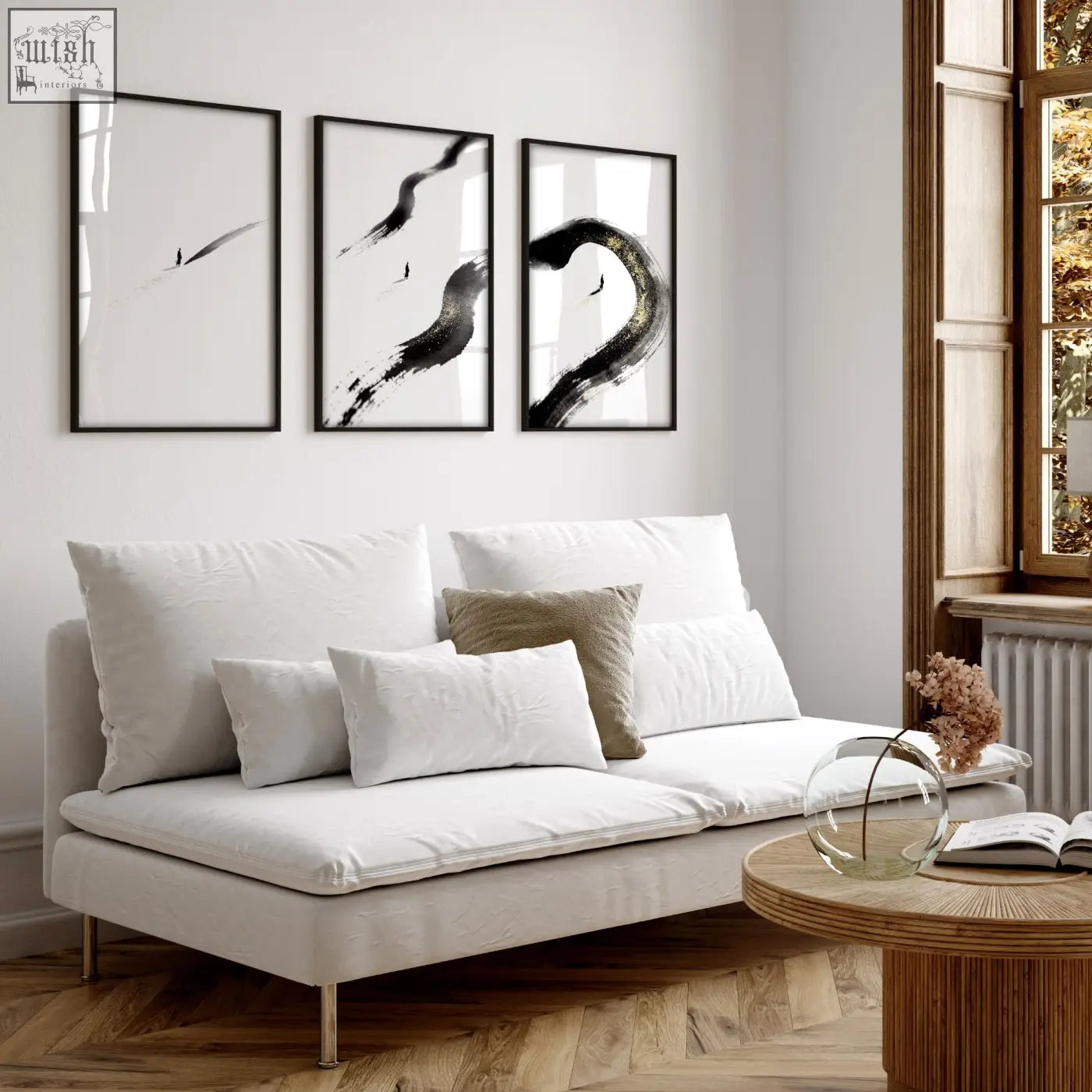 White upholstered sofa with metallic legs and cushions in a living room featuring japandi zen ink brushstroke wall art set
