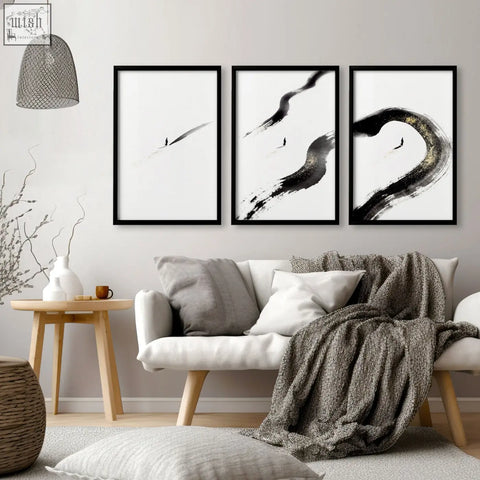 Three black-framed abstract ink brushstroke wall art pieces in black white and gold tones perfect for living room wall decor