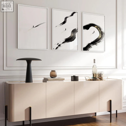 Cream-colored sideboard with sleek minimalist design and black legs in a living room with japandi zen ink brushstroke wall art set