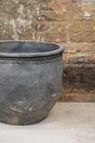Big old grey asian pots ceramic planter with dark gray weathered finish embossed circular patterns and rope band near rim