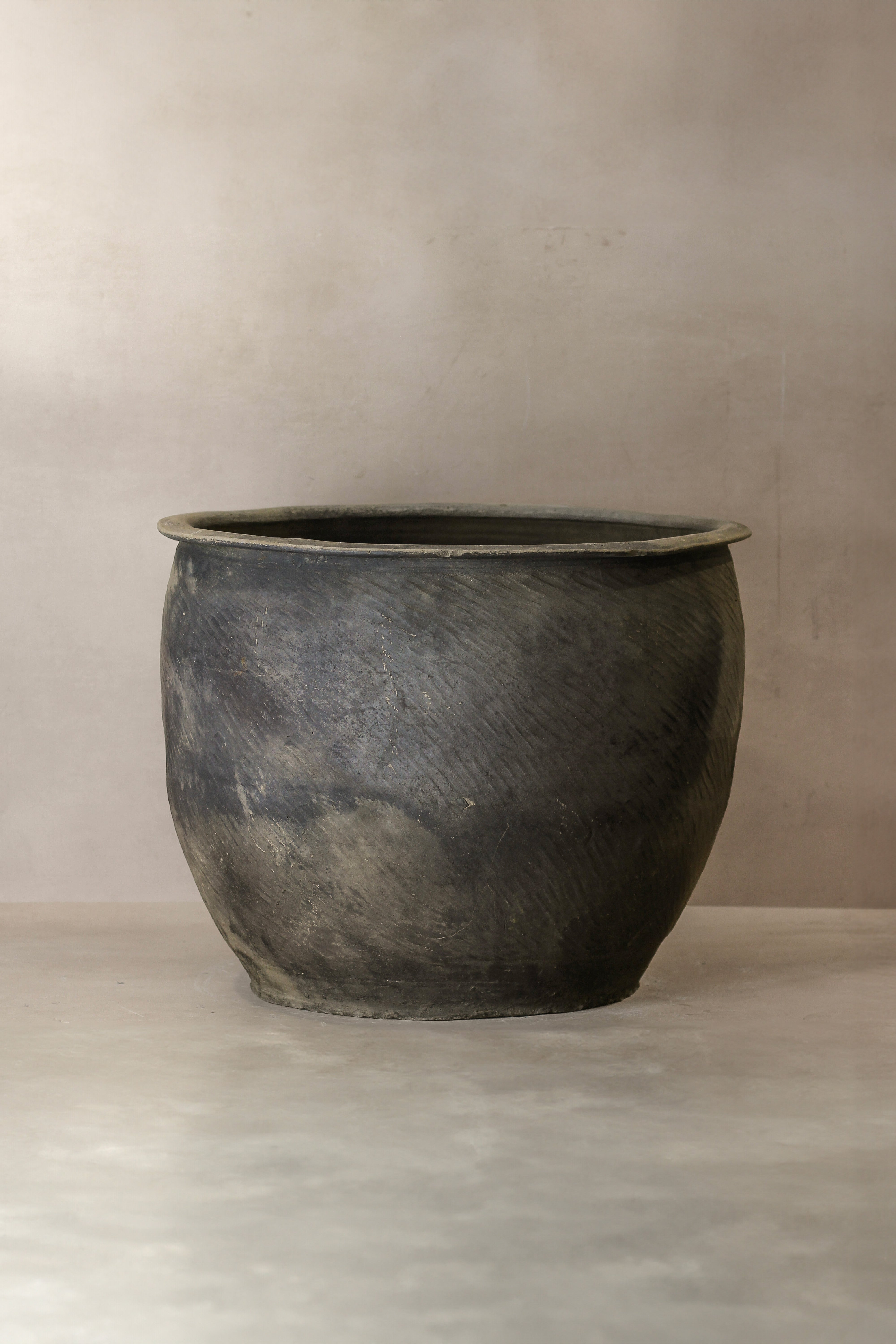 A rustic dark gray ceramic grey asian pot with a textured surface and wide rim from big old grey asian pots l016