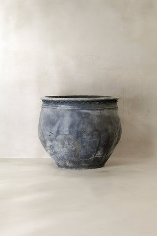 A weathered dark gray metal planter with textured surface and beaded rim from big old grey asian pots l020