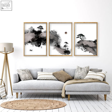 Three framed black and white japanese ink landscape art prints with minimalist wooden frames above a gray sofa in living room