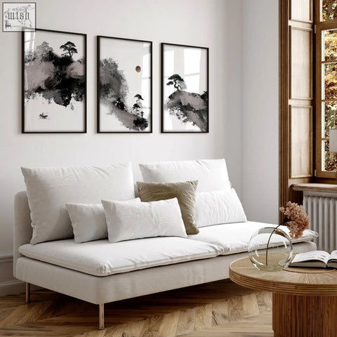 White upholstered sofa with metallic legs and cushions in living room featuring big painting japanese ink art prints set of 3