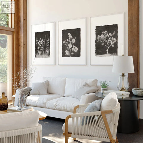 White woven wicker armchair with light wood frame next to french country big wall art for living room with dark floral wildflowers