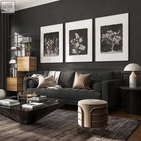 Dark gray upholstered sofa with beige taupe pillows next to french country big wall art featuring dark floral wildflowers in living room
