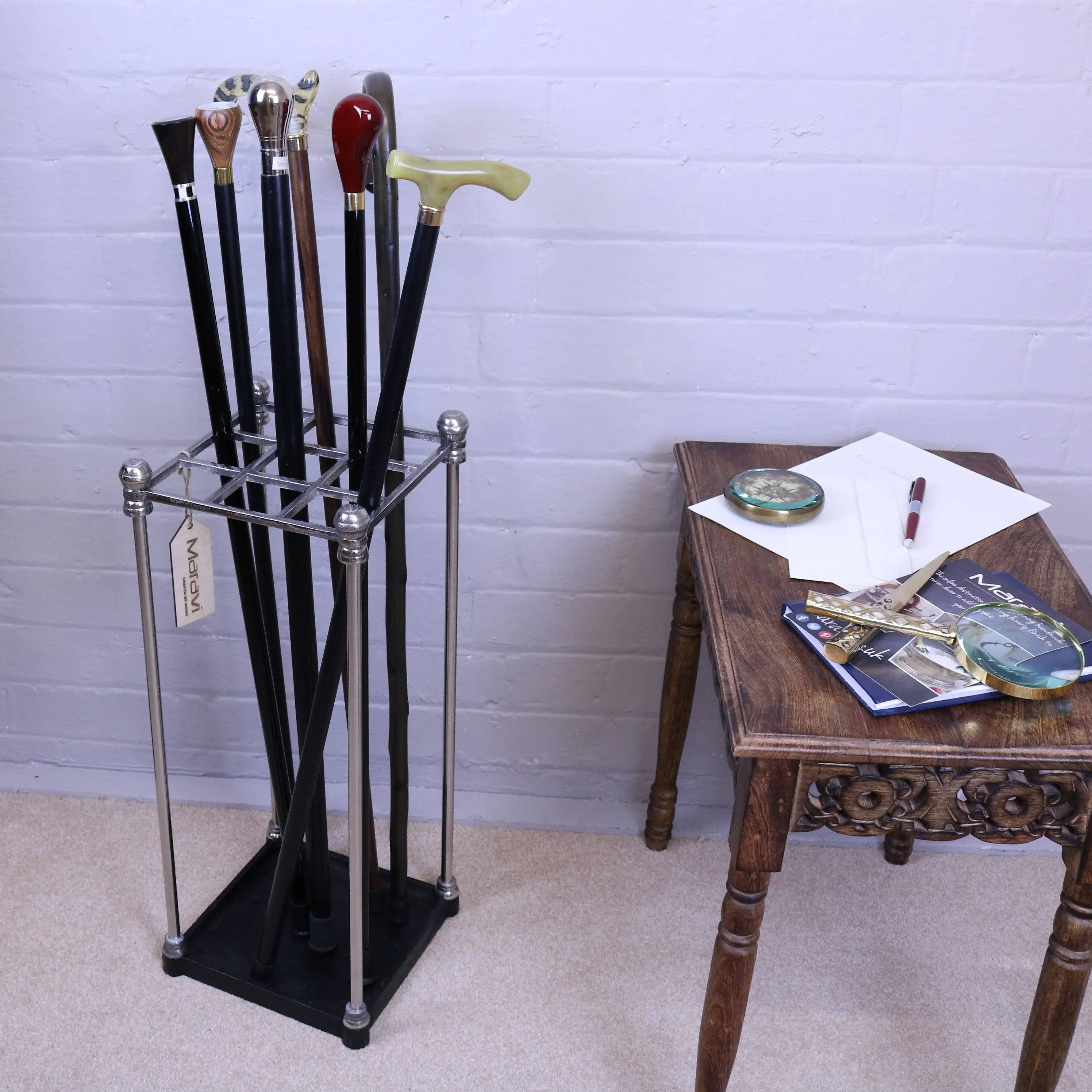 A bitlan walking stick stand in sleek chrome and black metal holding walking sticks with colorful varied handles