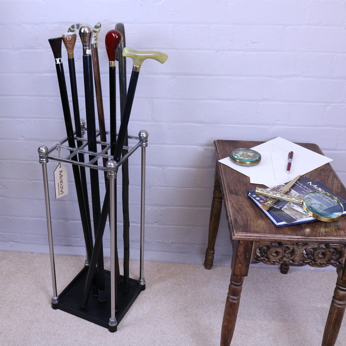 A bitlan walking stick stand in sleek chrome and black metal holding walking sticks with colorful varied handles