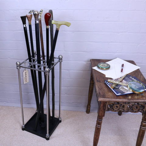 A bitlan walking stick stand in sleek chrome and black metal holding walking sticks with colorful varied handles
