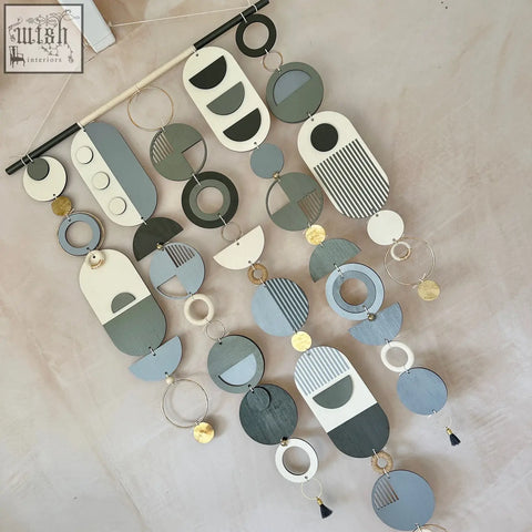 Modern geometric wall art with hand painted wooden discs in black grey and white featuring minimalist patterns