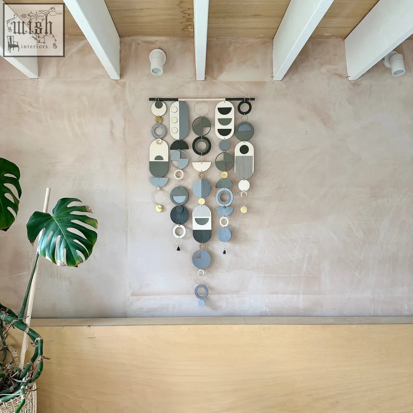A modern hand painted wall art featuring layered circular and oval shapes in muted greys and metallic accents